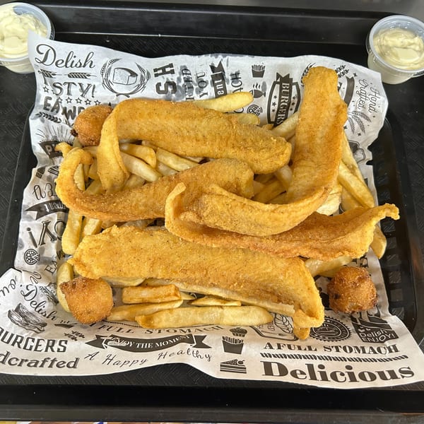 A fried fish and hush puppy platter with french fries on branded paper, with two dipping sauces.